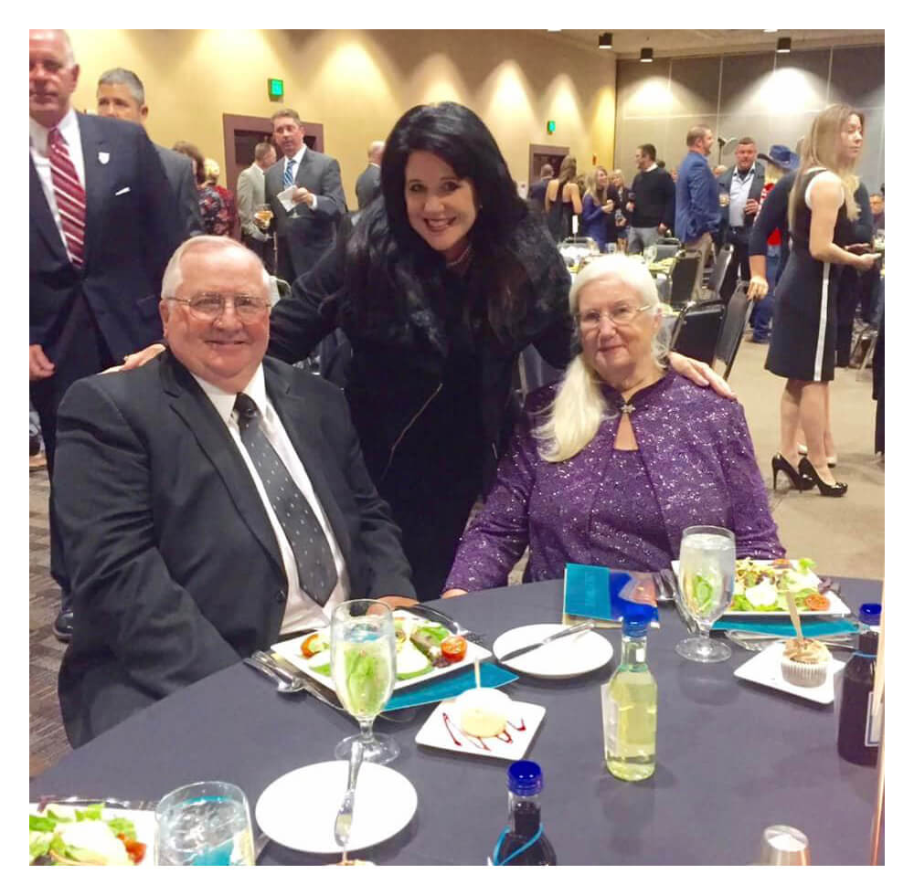 Gina Mosbrucker at an event posing for a photo with a man and woman